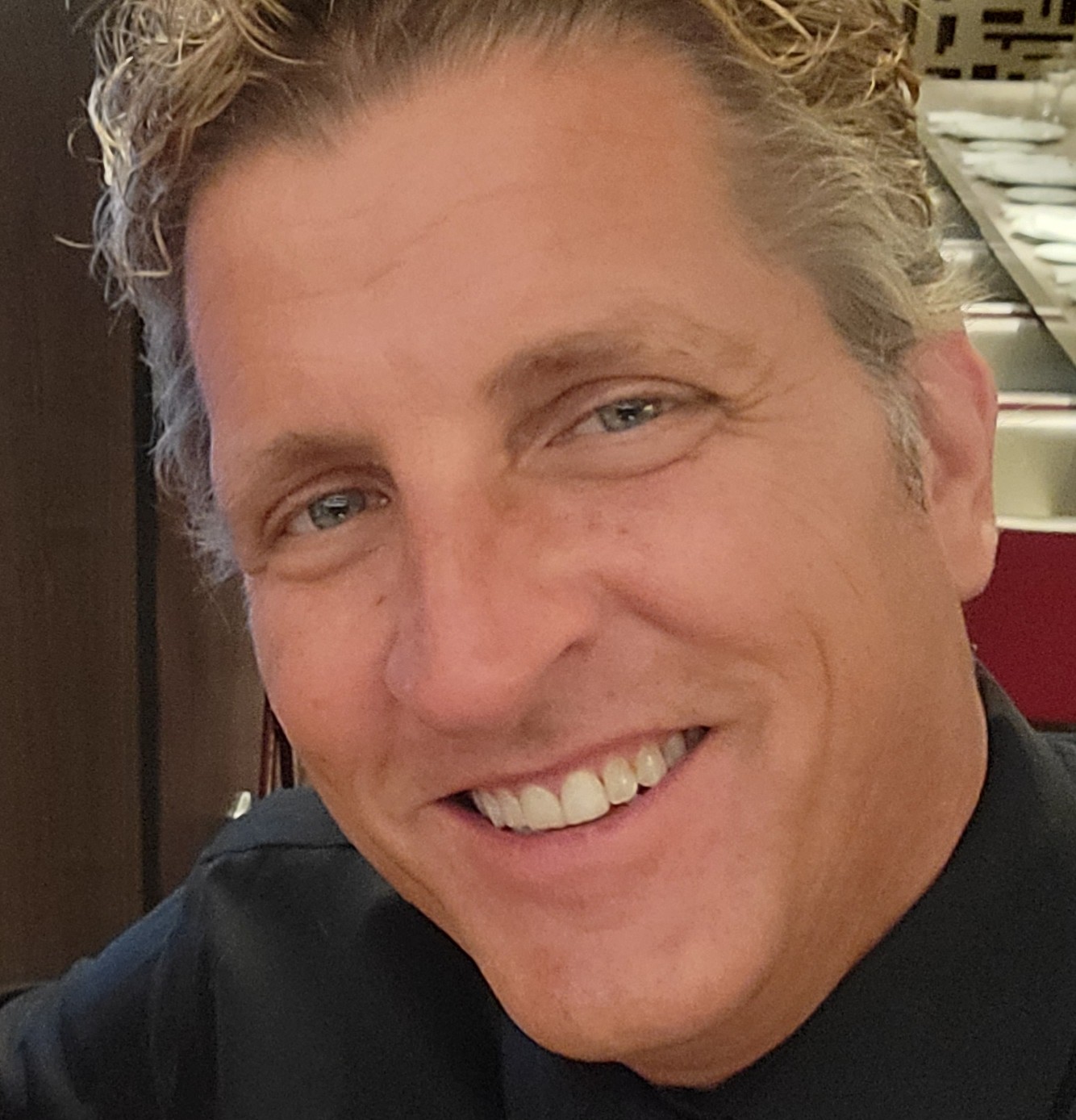 Justin Lambakis, smiling, photographed close up